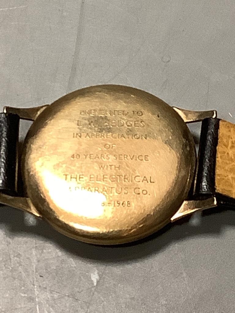 A gentleman's 1960's 9ct gold Tudor manual wind wrist watch, on a leather strap (lacking winding crown), with case back inscription, together with a Victorian gilt metal, amethyst and seed pearl brooch, 22mm.